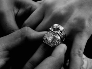 A stunning close-up of wedding rings being exchanged, captured in black and white to highlight the elegance.